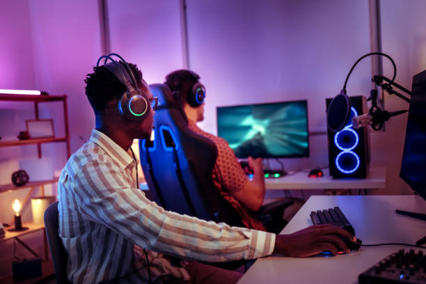 istock Two young gamers playing video game in neon lighted room 2170026388