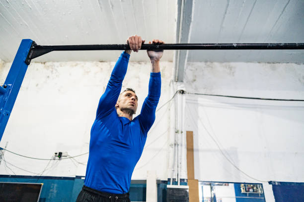 Mature man training on gymnastics bar at gym