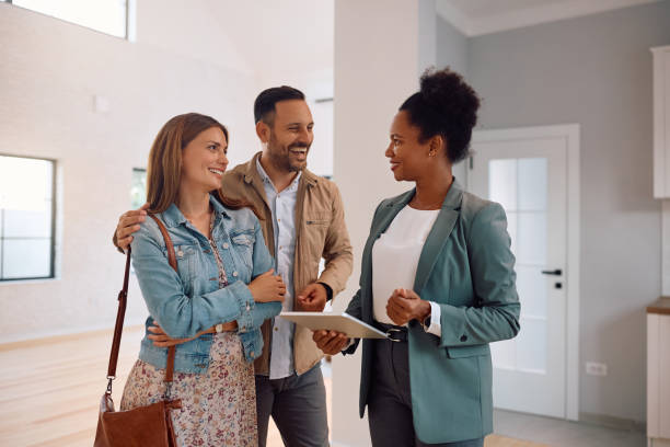 istock Happy couple and real estate agent using digital tablet during open house day. 2170030561