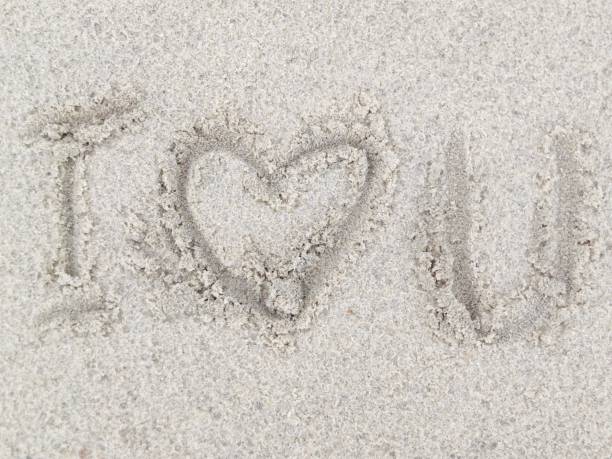 Defocused scribbles on the sand with I love you words