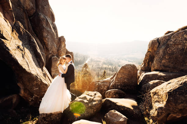 istock cliff overlooking the mountains. the newlyweds are hugging each 2170038621