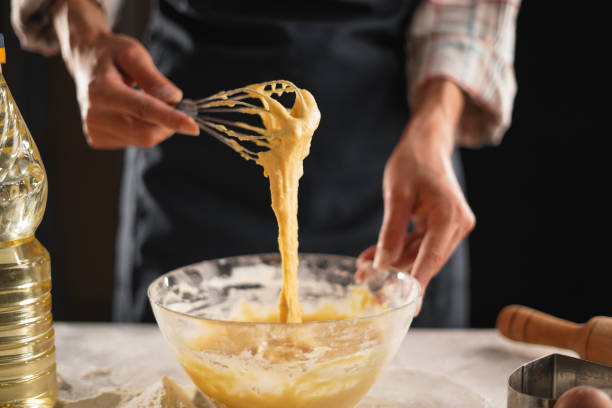 istock Whisking dough mixture in bowl during baking preparation, close-up 2170041419