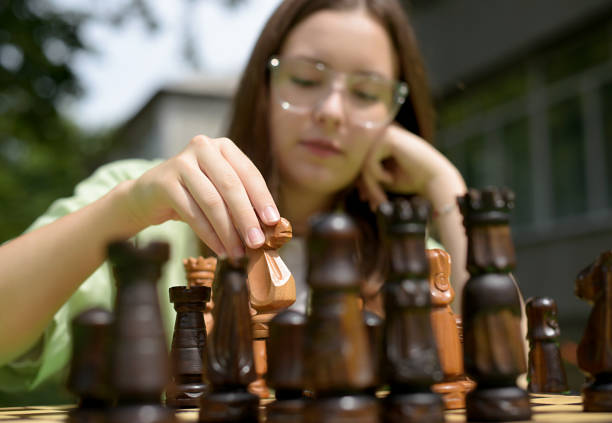 girl playing chess in the park. spending time
