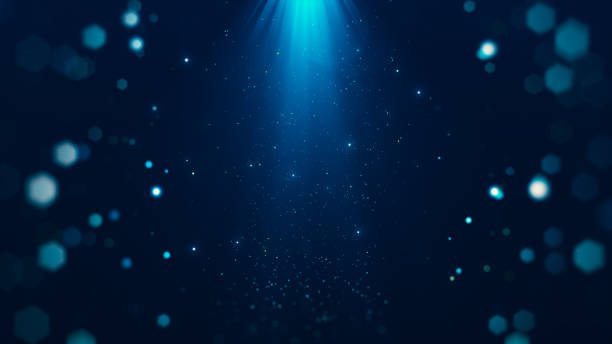 istock Abstract particles with glowing beams from above surrounded by bokeh on dark blue background. 2170050669