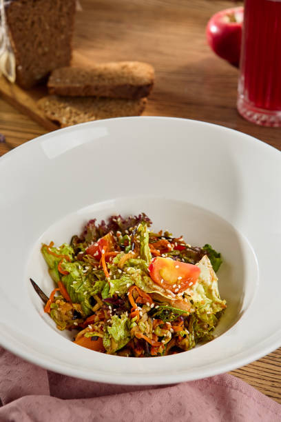 istock Fresh Vegetable Salad in a White Bowl on a Wooden Table 2170052977