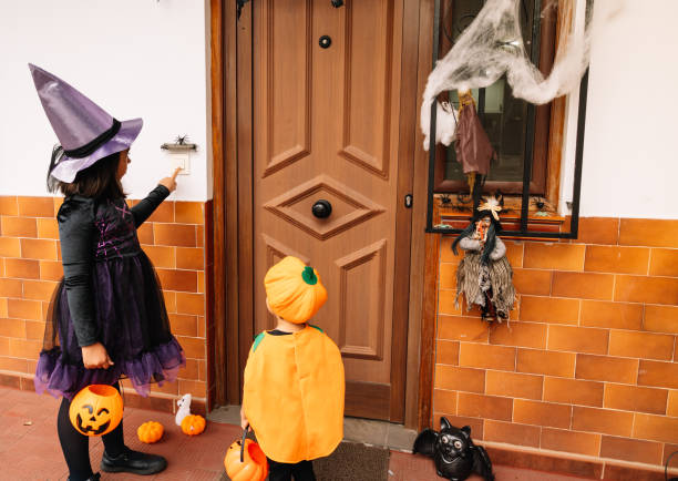 istock A girl dressed as a witch with her little brother dressed as a pumpkin 2170057452