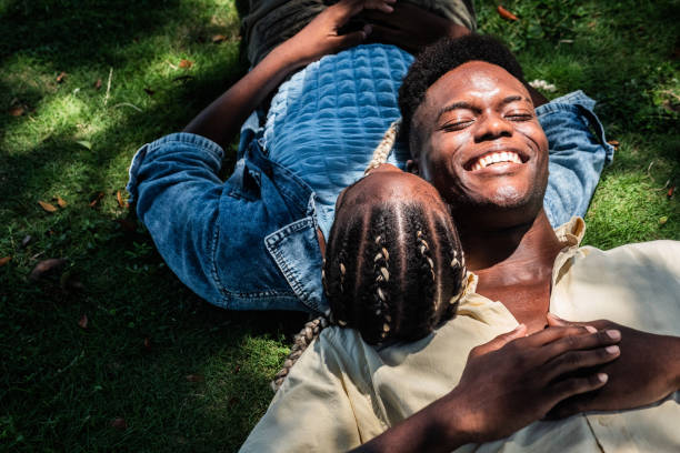 istock Young couple lying on grass at public park 2170059198