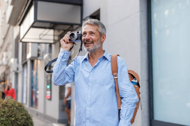 istock Smiling senior man capturing memories with a camera 2170059530