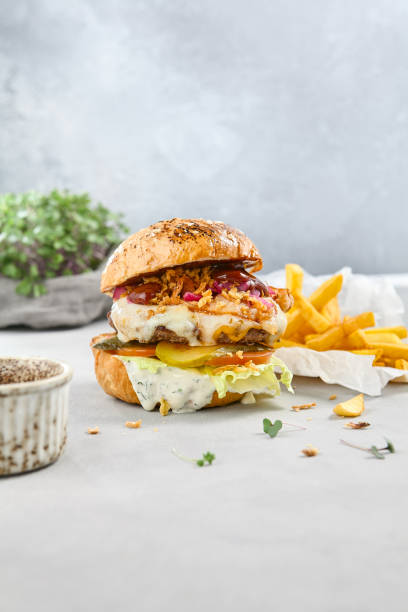 istock Delicious Burger with Patty and Two Sauces on Light Background 2170059532