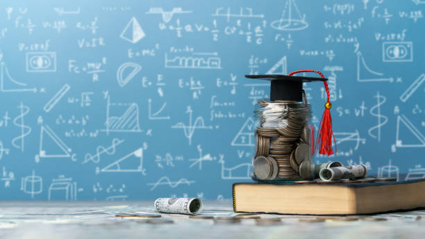 istock concept Student Success Scholarships, Students for College and University Tuition, Tuition for Education, Investment and Scholarships. stack of coins on book with graduation cap. 2170060385