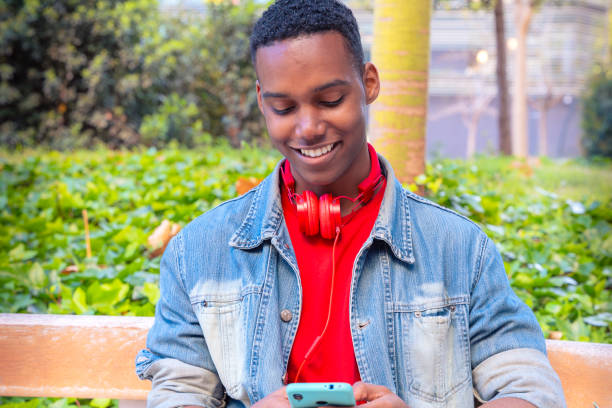 istock Happy student African American man browsing the internet using a mobile device 2170061866