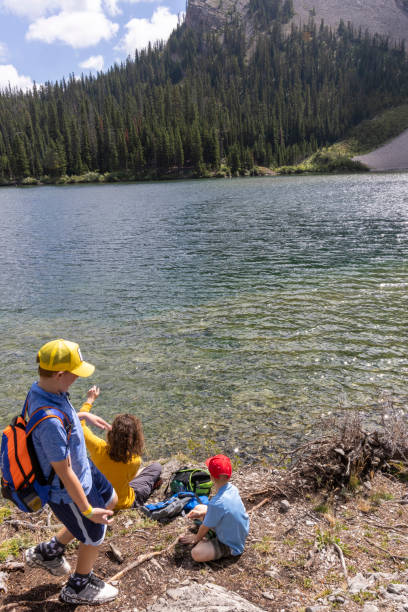 istock Brothers relax on lakeshore in mountains 2170065279