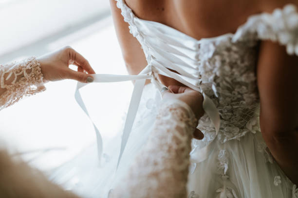 istock A bride adjusts a wedding dress 2170067548