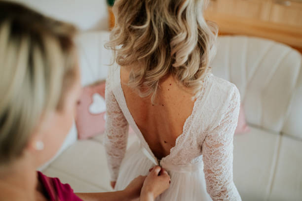 istock A bride adjusts a wedding dress 2170067669