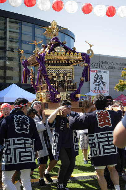 Burnaby, Canada - August 31, 2024: A team of participants shoulder the mikoshi at the opening of the Nikkei Matsuri. This annual festival celebrates Japanese Canadian culture at the Nikkei National Museum & Cultural Centre designed by Canadian architect Raymond Moriyama.