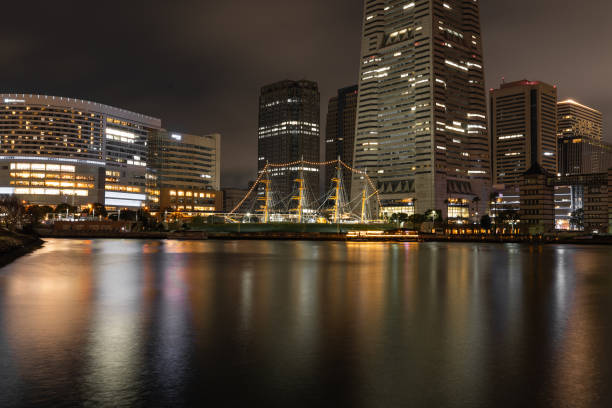 While the historical sail training ship Nippon Maru anchors near the bustling business towers of Yokohama Harbor, we see a clear contrast between the modern industries of Japan and its history in war and popular culture.