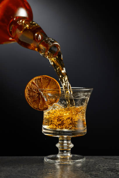 istock Rum or whiskey is poured from a bottle into a glass. 2170075486
