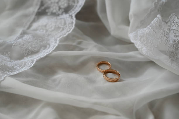 istock Two golden wedding rings  on lace 2170078292