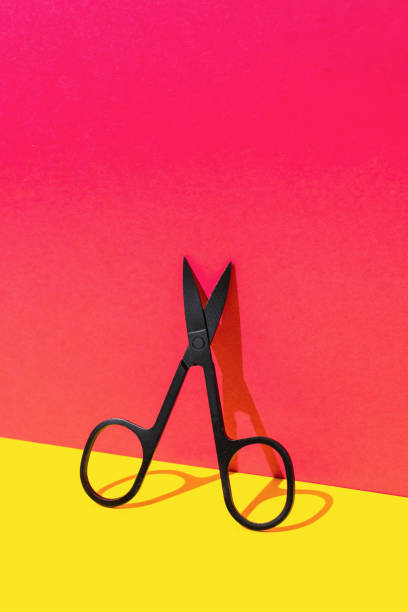 istock Minimalist Black Scissors on Vibrant Red and Yellow Background 2170078413
