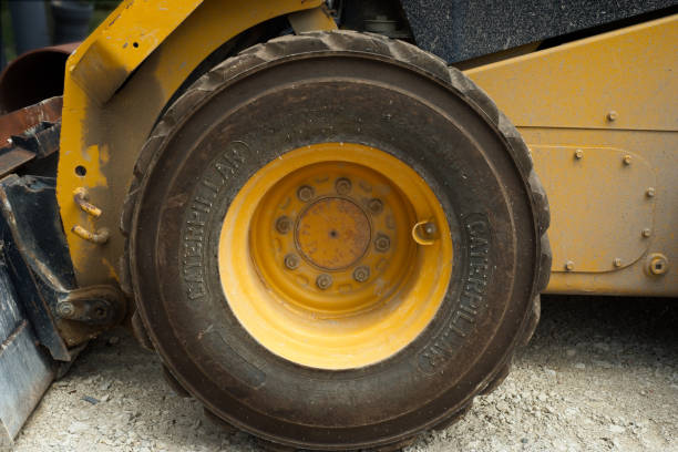 Twinsburg, OH, USA - July 18, 2024: Detail of a road work vehicle's front wheel as it sits on a gravel surface during a water line replacement project.