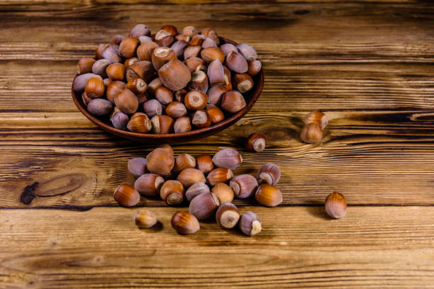 istock Plate with pile of hazelnuts on a wooden table 2170084105