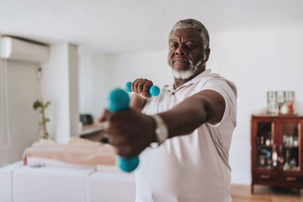 istock Elderly man exercising at home with dumbbell physiotherapy 2170084232