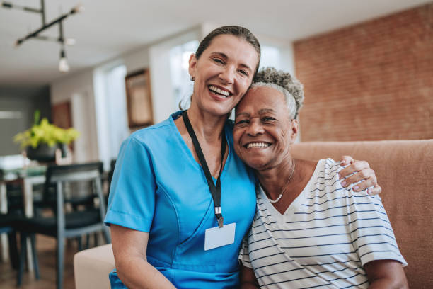 Home care healthcare professional hugging elderly patient stock photo