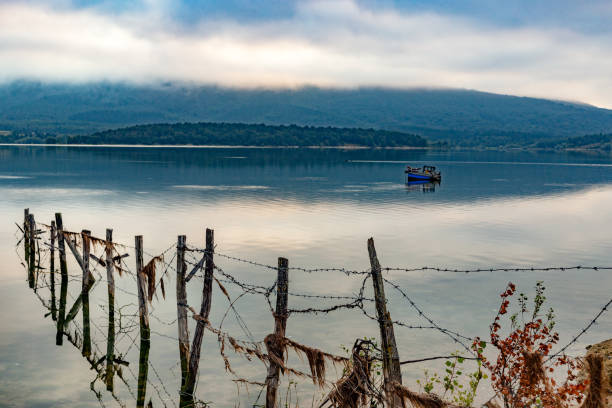 Ullíbarri-Gamboa Reservoir, Nanclares de Gamboa, Vitoria Gasteiz, Basque Country, Spain. Idyllic image of a calm lake under a cloudy sky at dawn.