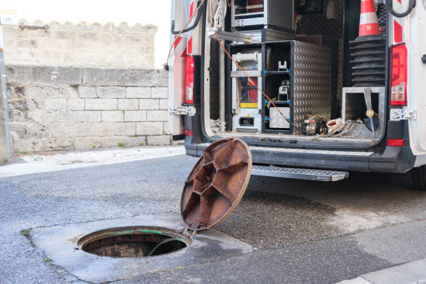 istock Open manhole cover and workers with repair tools. 2170089875