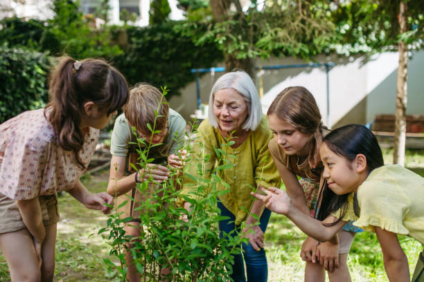 istock Kids learning about fruit tree seedling and fruit bushes, taking care of school garden during outdoor sustainable education, class in forest school. Concept of experiential learning and ecoliteracy. 2170090225