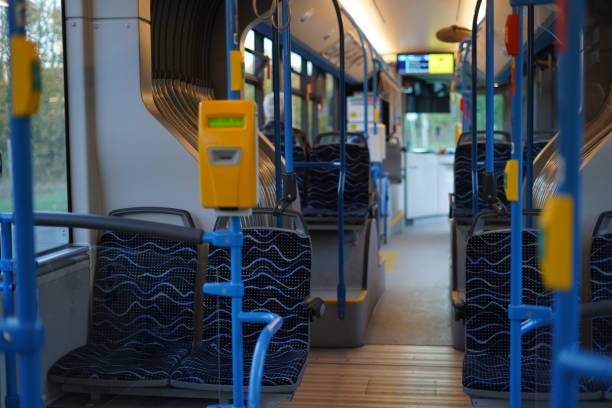istock interior of a modern bus, featuring patterned blue seats, yellow ticket validators, and blue handrails 2170094017