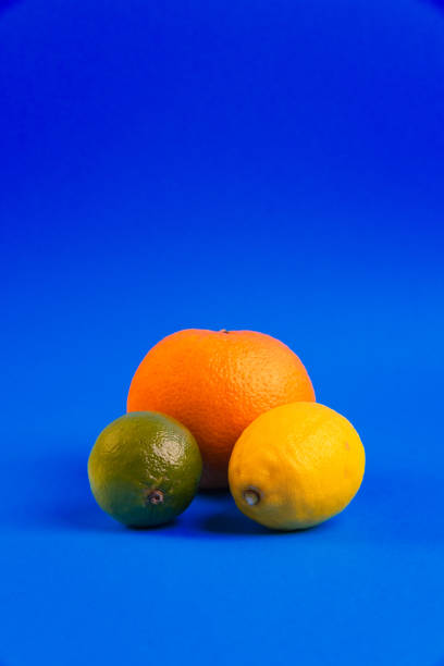 Lemon, Lime and Orange Arranged on Blue Background