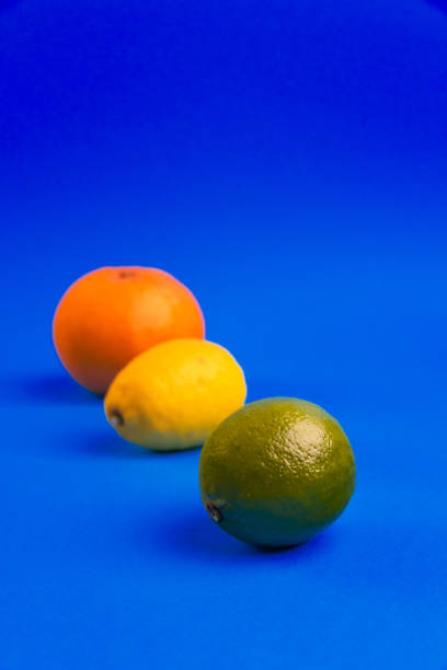 Lemon, Lime and Orange Arranged on Blue Background