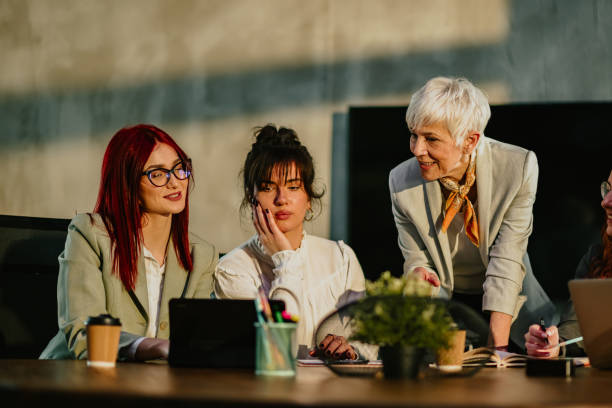 istock Mature manager tutoring and teaching her young staff at conference room 2170098103
