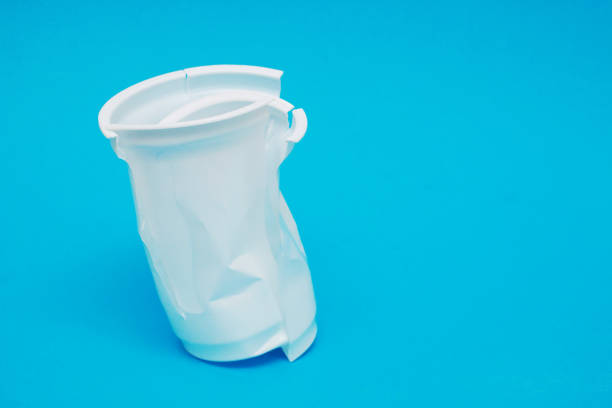 istock White plastic damaged drink glass on blue background. 2170104500