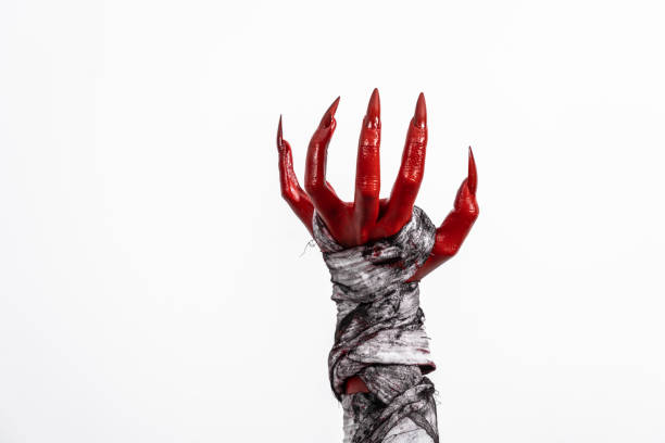 istock A terrifying red demon hand wrapped in a shroud, reaching out menacingly on a white studio background. This eerie, Halloween-themed image evokes fear and horror with its ghostly, undead appearance. 2170106061