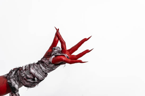 istock A terrifying red demon hand wrapped in a shroud, reaching out menacingly on a white studio background. This eerie, Halloween-themed image evokes fear and horror with its ghostly, undead appearance. 2170106118
