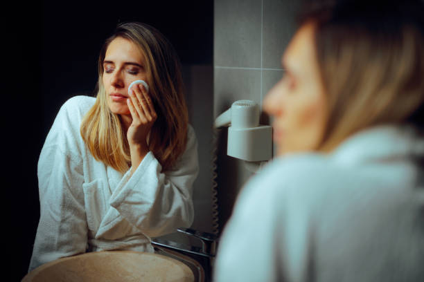 istock Woman Removing Make-up Using Cotton Pads in the Bathroom Mirror 2170106291