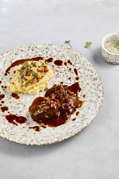 istock Gourmet Mashed Potatoes with Braised Beef Cheeks in Demi-Glace Sauce on Rustic Plate 2170109622