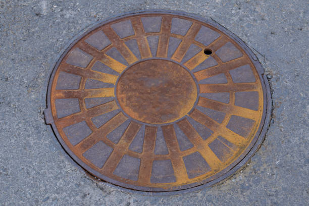 Cast-iron manhole cover storm sewer in the park close-up.