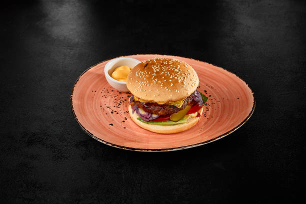 Juicy Beef Burger with Vegetables and Sauce on Modern Plate