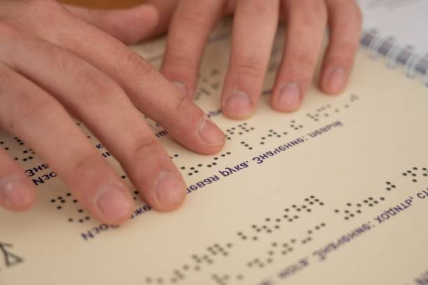istock Visually impaired man reading a braille book. 2170112860
