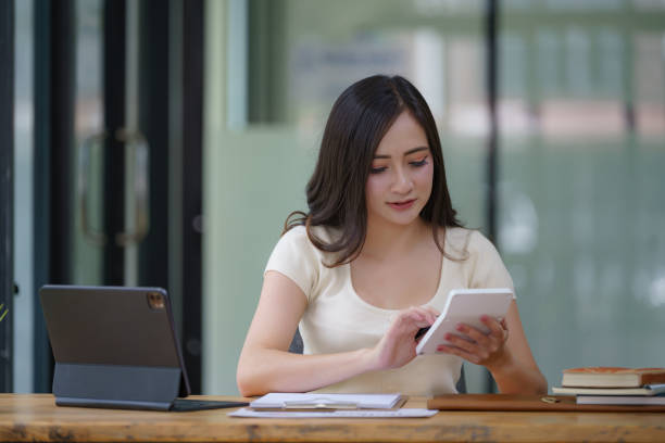 istock Asian businesswoman using a calculator to calculate work graph business data and analysis. 2170113754