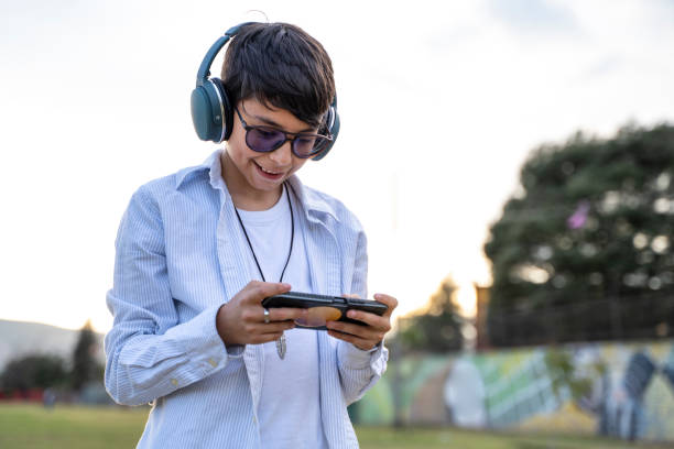 istock Young man using digital devices in the park at dusk 2170116679
