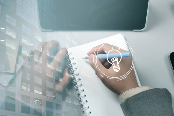 istock A person is writing in a notebook with a light bulb symbol on the page 2170117344