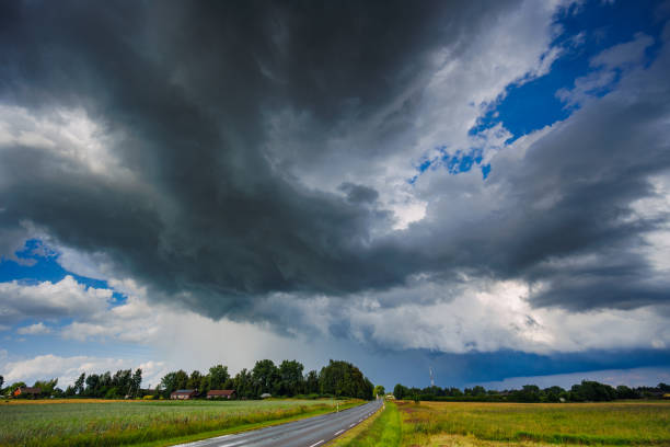 A car drives through rural landscape under storm clouds, creating an impressive scene with moody elements. Time-lapse 4K videoDark storm clouds are gathering over an extensive wheat field, creating a dramatic and intense weather scene