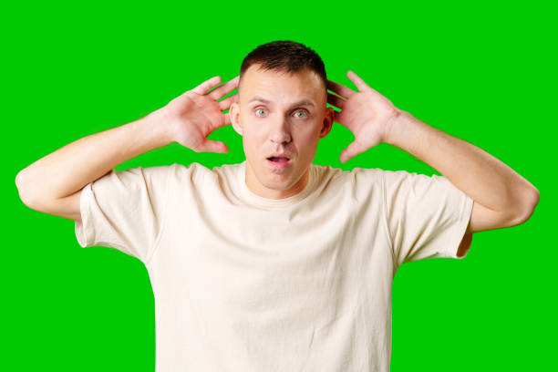 istock Cheerful Young Man Posing With Outstretched Hands Against a Bright Green Background 2170128353