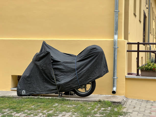 istock Motorcycle under protective cover next to a building 2170128488