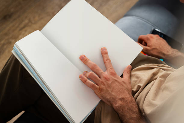 Close Up of Person's Hands Holding Open Book While Sitting close up