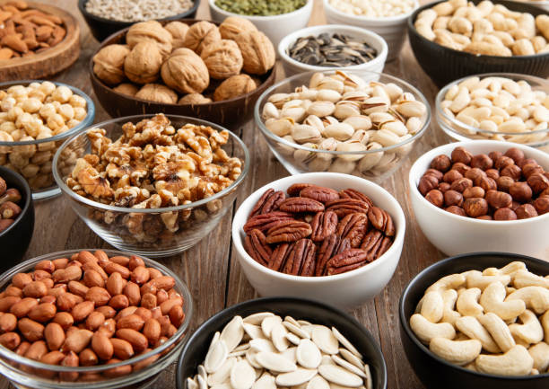 istock Mixed raw nuts and seeds in bowls on kitchen table.Peanut,hazelnut,walnut,almonds,pistachio,sunflower,pumpkin,chia and cashew.Macro 2170130507